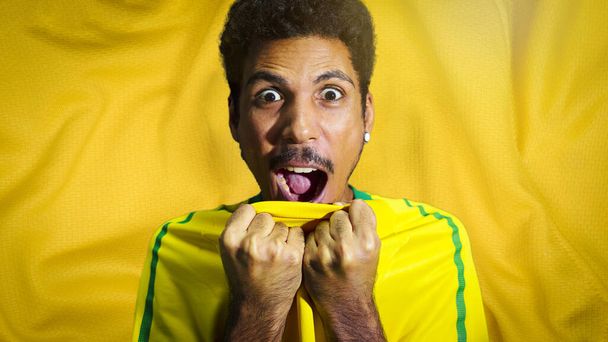 Male black athlete with uniform smiling. Sportsman isolated in a colored fabcric background. - 写真・画像