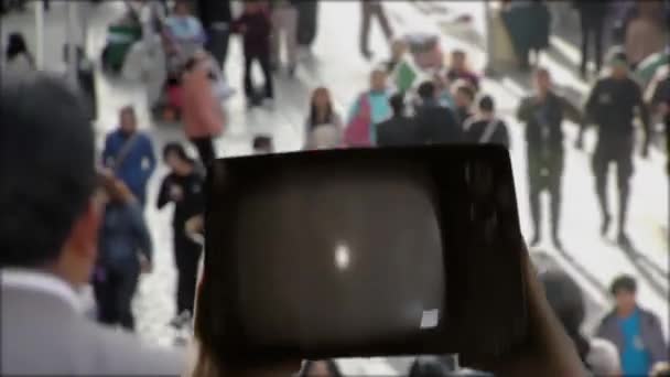 Mani che tengono il vecchio televisore con il pugno serrato sullo schermo su Blurred Crowded Street. Black Lives Matter Concept.  - Filmati, video