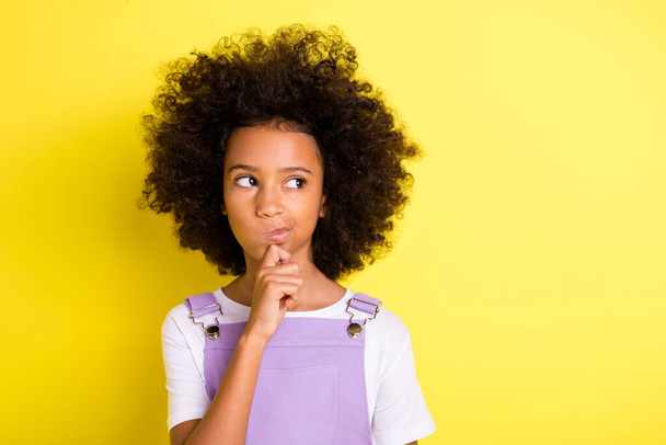 Portrait of nice minded smart wavy-haired girl overthinking creating idea copy space isolated over bright yellow color background - Foto, afbeelding