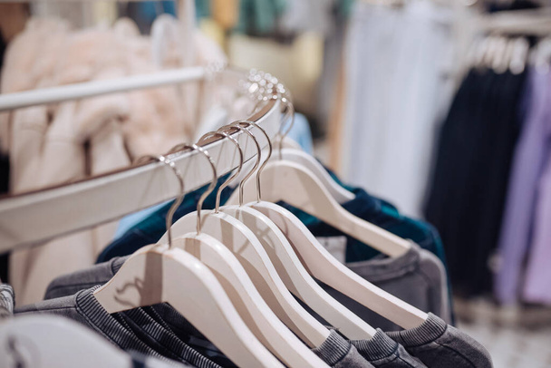 Stijlvolle kleren aan een hanger in een winkel. Nieuwe collectie jassen. - Foto, afbeelding