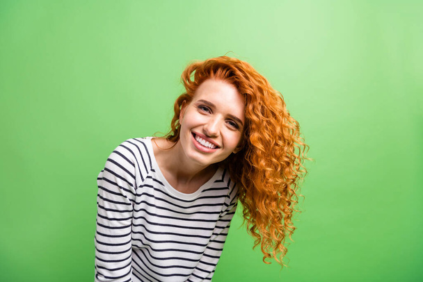 Photo of shiny adorable young woman wear striped shirt smiling isolated green color background - Foto, Imagem