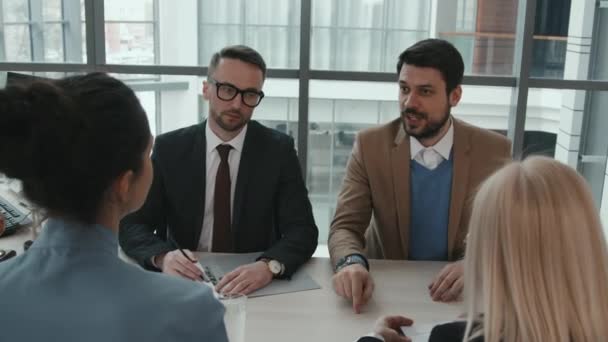 Mediana oportunidad de abogados profesionales discutiendo caso legal sentados juntos en la mesa de reuniones en la sala de oficina - Metraje, vídeo