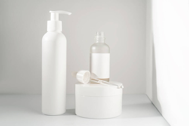 Three jars of cosmetics stand on a white background. - Zdjęcie, obraz