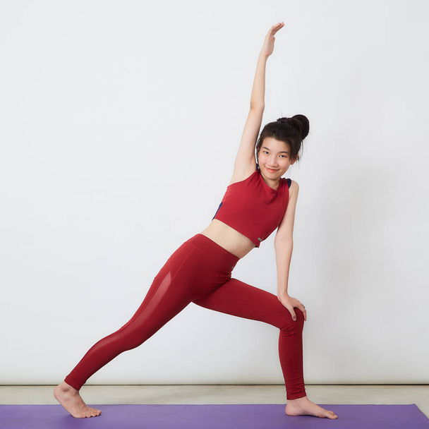 Young Asian woman exercise over light background - Fotografie, Obrázek