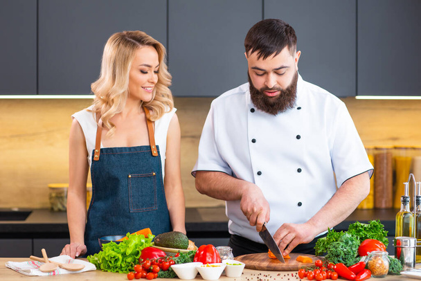 Young woman and man prepare food and host a cooking show. The bloggers stream from modern kitchen. Healthy food preparation. - Fotografie, Obrázek