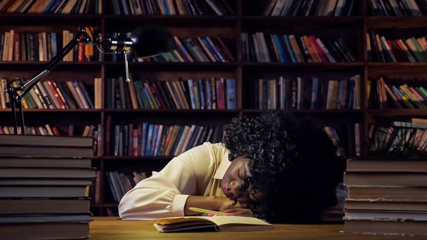 Afro-Amerikaanse vrouw moe van de voorbereiding op tests slaapt - Foto, afbeelding
