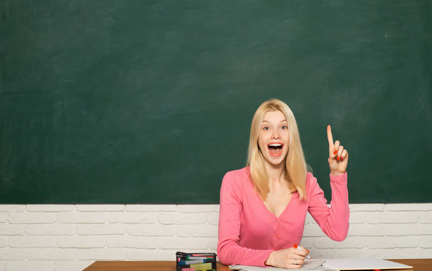 Excited amazed teacher. Portrait of young caucasian female teacher or student. Cheerful teacher on lesson. Teaching. Teacher woman holding empty hand for product. - 写真・画像