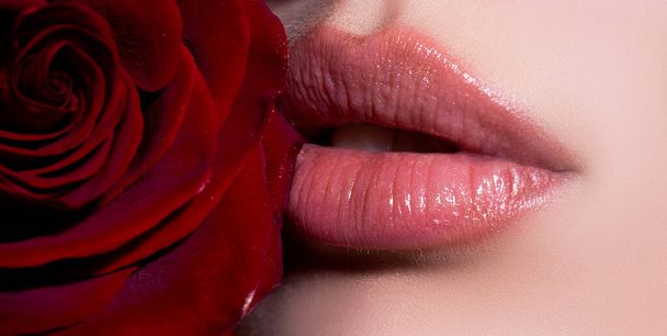 Lips close up with red rose. Cosmetics make up advertising. Beautiful female perfect red lips. - Photo, Image