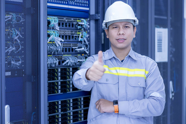 IT-insinööri seisoo ja poseeraa Crossed Arms in Working Data Center Server Room Server Computers Työskentely Rack. - Valokuva, kuva