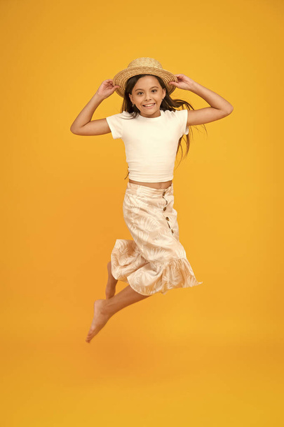 Cheerful small girl summer outfit jumping, levitation concept - Foto, afbeelding