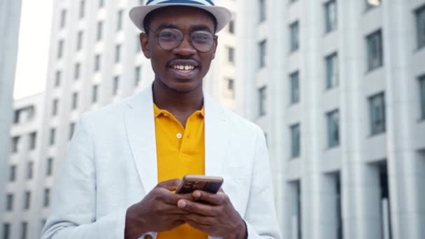 Sonriente hombre afroamericano en gafas y tipos de traje - Metraje, vídeo