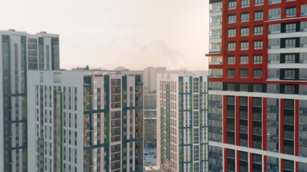 Luftaufnahme eines Großstadtviertels mit sonnigen Straßen und Wohnhochhäusern vor bewölktem Himmel. Video. Schöne bunte Stadt, Konzept der Urbanisierung. - Filmmaterial, Video