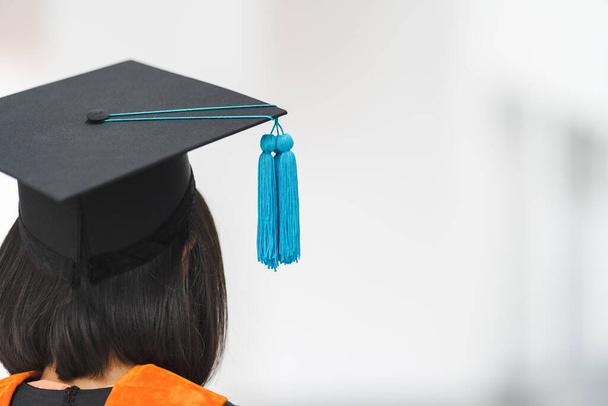 Close-up shot of a university graduate in graduation gown holding a degree certification with mortarboard to shows and celebrates success in the college commencement day. Education stock photo - Photo, Image