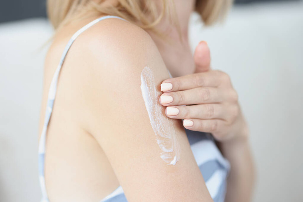 Woman applying moisturizer to shoulder skin closeup - Zdjęcie, obraz