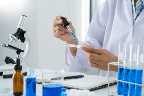 Scientist wear lab coat and protective wear are working with research or doing investigations with test tubes in experiment, Laboratory and development concept. - Foto, Imagem