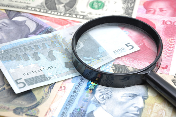 Magnifying glass on money background - Foto, afbeelding