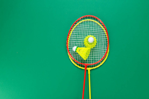 Two shuttlecock and badminton racket. on a green background. Concept summer relaxation. - Foto, Imagem