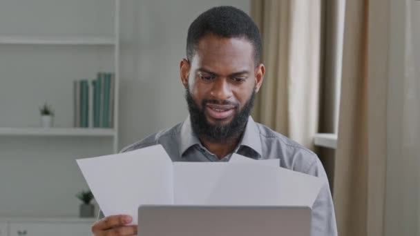 Sinirli, sakallı, Afrikalı bir işadamı, ofis çalışanı belgelerde bilgi arıyor, gergin bir şekilde kağıt kırıntıları bırakıyor. Hataları ve borçları yanlış bildirerek öfkeli muhasebeci - Video, Çekim