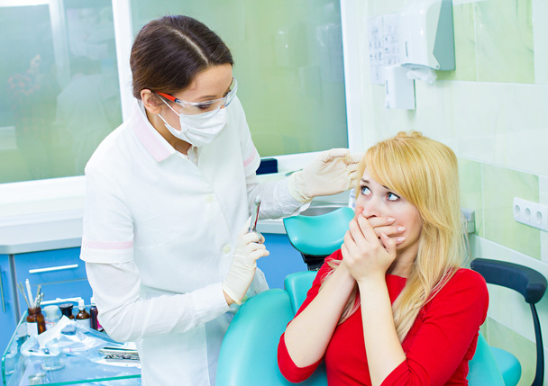 Paciente jovem em consultório odontológico, com medo de injeção anestésica
, - Foto, Imagem
