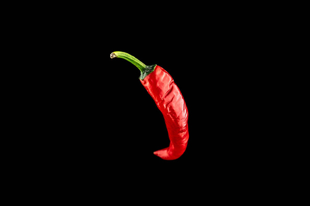 Red chile pepper. Spicy chile cayenne pepper isolated. Red hot chili paprika on black background. Ingredient for fresh spice mexican food - Photo, Image