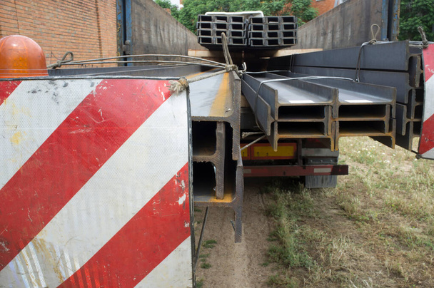 Materiali da costruzione camion caricato con travi in acciaio. Concetto di limitazione della lunghezza del carico sovradimensionato - Foto, immagini