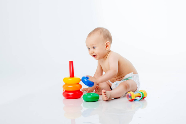 a baby boy with a multi-colored pyramid is isolated on a white background; - Photo, Image