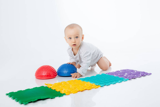 a baby boy with an orthopedic mat and a hemisphere is isolated on a white background - Photo, Image