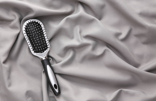 Escova de cabelo em um fundo de seda cinza. Beaty natureza morta - Foto, Imagem