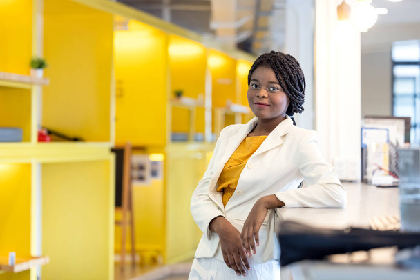 Portré fekete nő a modern irodában A coworking háttér, Afro nő sárga pulóver - Fotó, kép