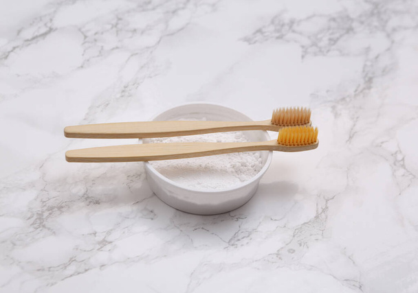 Eco-friendly bamboo toothbrushes and tooth-powder on marble background. - Foto, imagen