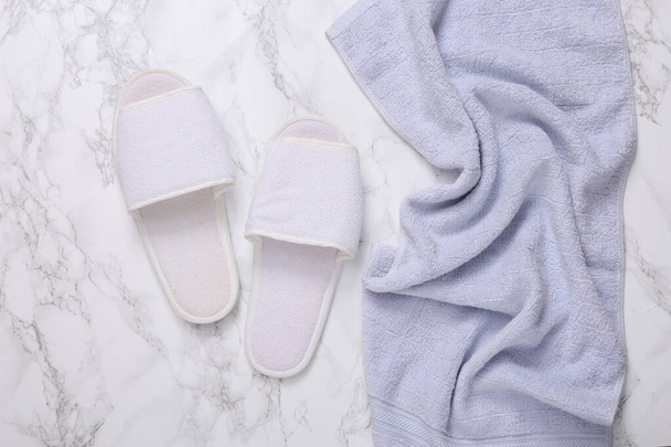 Bathroom hotel accessories. Towel and slippers on marble background - Φωτογραφία, εικόνα