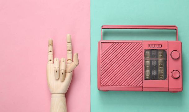 Fm радіо і дерев'яна рука показують рок-жест на рожевому синьому фоні. Краєвид. Мінімалістична музична концепція. Рок-н-рол - Фото, зображення