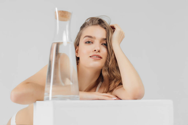 Young woman with glass bottle of water - Foto, afbeelding