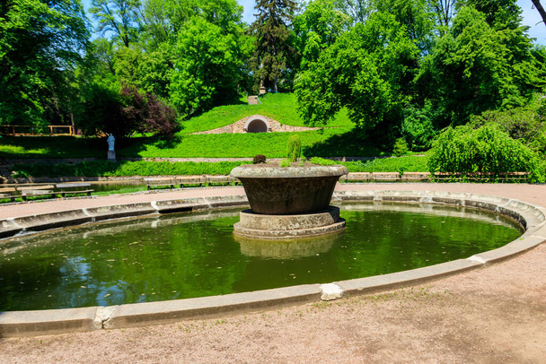 Большая каменная клумба посреди искусственного пруда в парке Софиевка в Умани, Украина - Фото, изображение