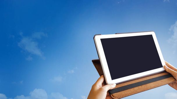 Tabletta fekete képernyő tartsa a kezét a kék háttér - Fotó, kép