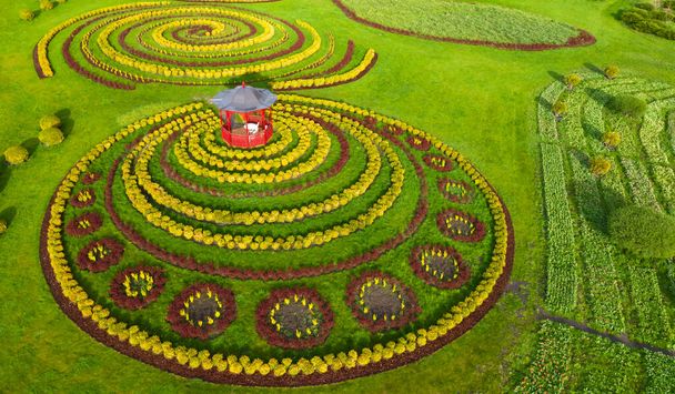 Gazebo no gramado ao lado de um canteiro de flores no parque. Ótimo lugar para meditação. Vista aérea. - Foto, Imagem