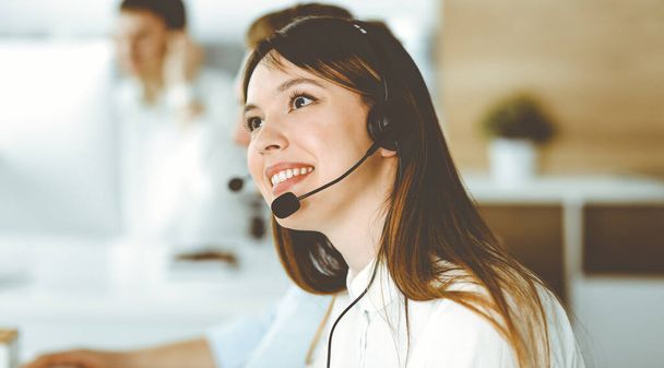 Group of diverse operators at work in call center. Beautiful asian woman sitting in headset at customer service office. Business concept - Φωτογραφία, εικόνα