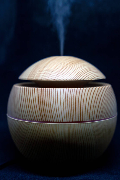 A round wooden texture Humidifier spreading steam into the living room. Ultrasonic humidifier atomizes water vapor. Humidification. Health care concept.care concept, - Photo, Image