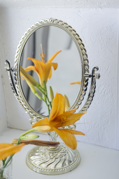 El lirio naranja cerca del espejo. Flores y reflejo espejo. - Foto, imagen