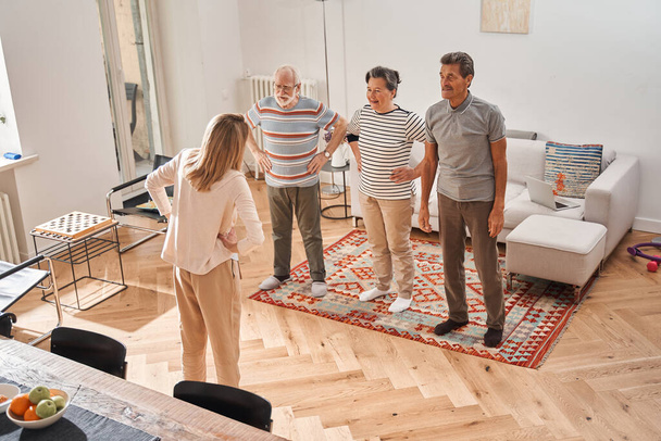 Retirement people doing morning exercises with their caregiver - Fotó, kép