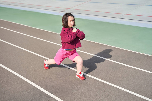 Midget woman doing stretching at the stadium at the morning - Fotoğraf, Görsel