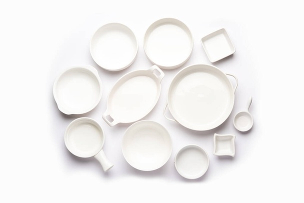 Kolekce prázdných barevných keramických misek. Skupina nádobí zachytil shora, pohled shora, byt ležel na bílém pozadí - Fotografie, Obrázek
