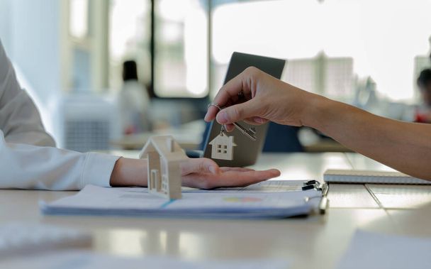 Immobilienmakler geben den Kunden nach Vertragsunterzeichnung Hausschlüssel. Das Konzept für den Kauf einer Immobilie oder die Eigenheimzulassung. - Foto, Bild