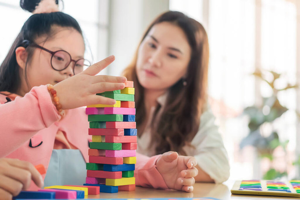 Happy asian mother playing education toy with their daughter down syndrome child in living room, Activity happy family lifestyle concept. - Photo, Image