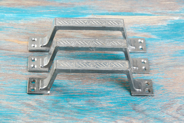 Antique aluminum door handles on wooden background. Copy space for text. - Photo, image