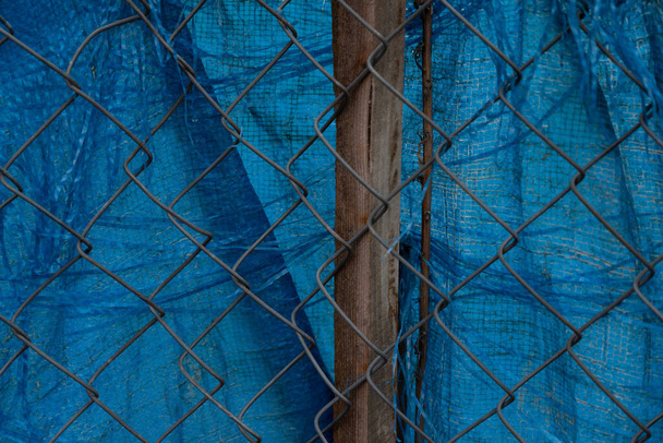 background in the form of a netting mesh and blue fabric - Photo, Image