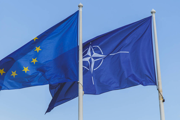 Флаги Европейского Союза и НАТО на фоне голубого неба - Фото, изображение