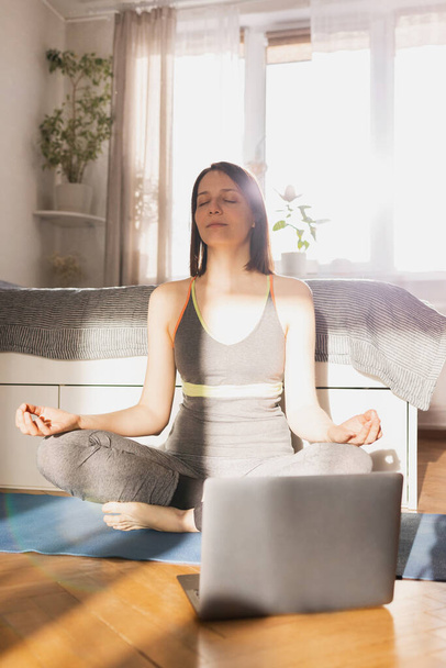 young beautiful caucasian woman doing yoga and meditation at home - Foto, imagen
