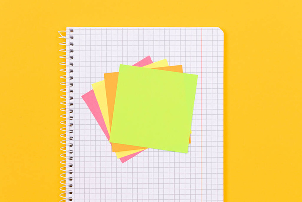 A Notepad with Sticky Notes on Yellow Table - 写真・画像