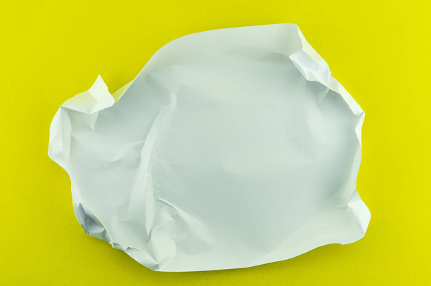 Белая скомканная бумага на фоне желтой бумаги. - Фото, изображение
